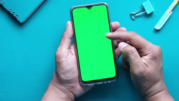 Top View of Man Hand Using Smart Phone on Office Desk  alt