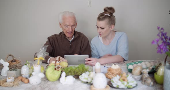 Granddaughter with Grandfather Using Digital Tablet alt