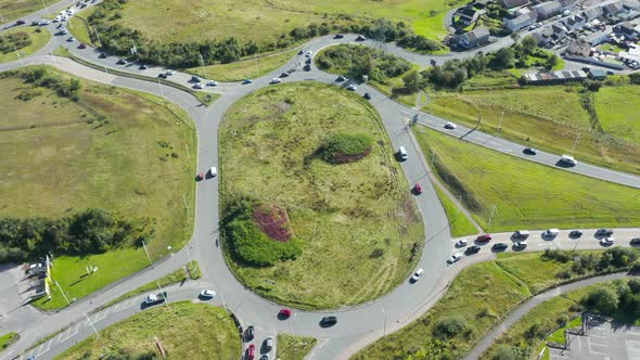 Static aerial view of traffic using a busy roundabout 