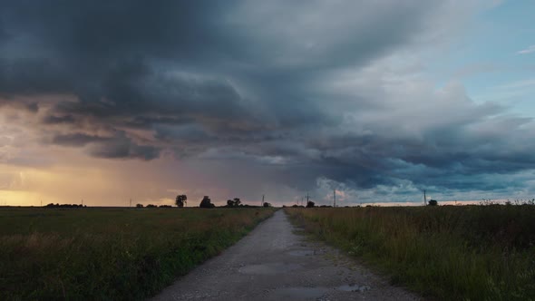 Time lapse of storm clouds over field at sunset