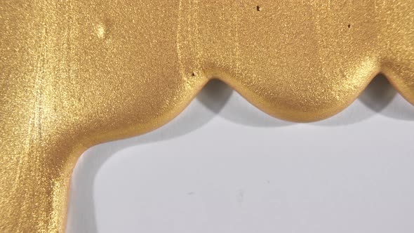 Gold Gel Fluid with Flowing Down on a White Surface alt