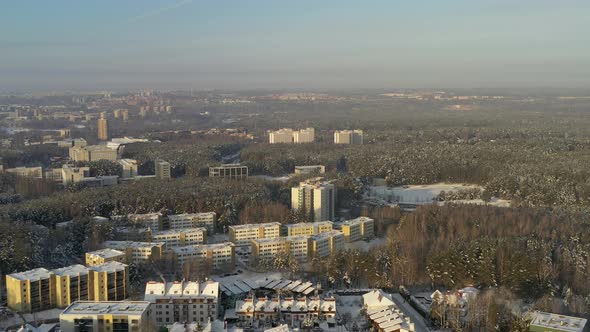 AERIAL: Buildings in Forest on a Cold Bright Warm Looking Day in Winter alt