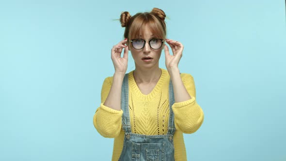 Silly Young Woman with Bangs and Buns Haircut Looking Confused Takeoff Glasses and Listening Closer