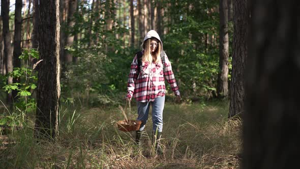 Young Confident Woman Searching Mushrooms in Forest with Tree Passing at Front alt