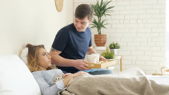 Girl Lies Guy Serves Breakfast in Bed Couple Drinks Coffee alt