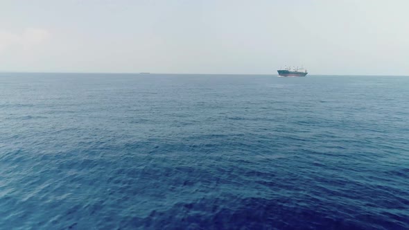 Drone Shot Of Commercial Ship Vessel On Deep Blue Sea
