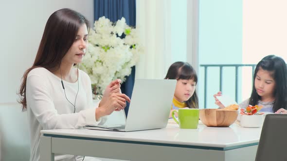 Working mother discussing contract conference call via video call at home with her daughter
