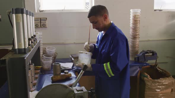 Mixed race man working in factory alt
