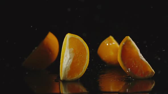 Orange Falls On A Table And Pieces Scatters In Different Directions