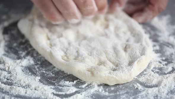Baker kneads the dough with his fingers