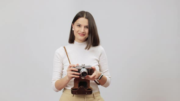 Joyful Woman In Beige Outfit Making A Shot On Her Vitage Film Photocamera