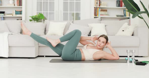 Young Brunette Woman is Having Abdominal Press Exercises