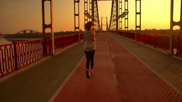 Woman Is Running Along the Bridge alt