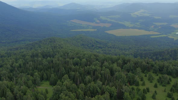 Green forest and valley on mountains of Manzherok under blue sky alt