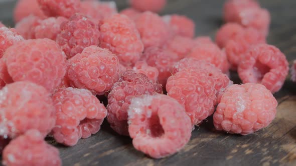 Dolly Shot a Bunch of Red Raspberries on a Dark Wooden Table Closeup alt