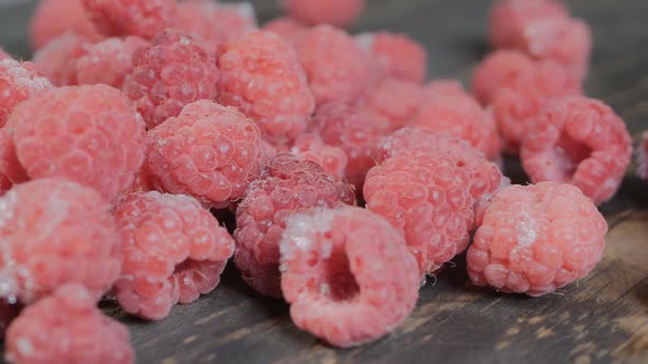 Dolly Shot a Bunch of Red Raspberries on a Dark Wooden Table Closeup