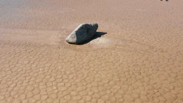 Scenic Close Up View of Rock on the Wet Cracked Surface of Death Valley Desert alt