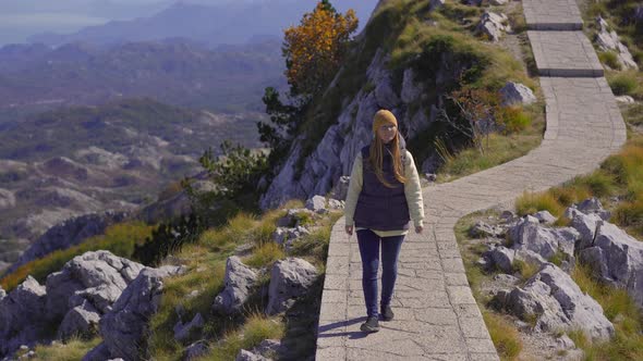 A Young Woman Traveler Visits the View Point on the Top of the Lovcen Mountain alt