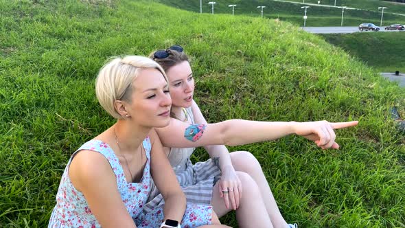 A Pair of Lesbians Sit in a Park on the Grass and Talk
