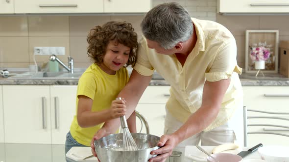 Happy Father and Cute Curly Hair Son Cook Together Stirring Dough with Whisk