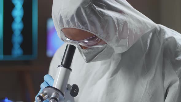 Asian Doctor In Protective Suit Examining Chemical Test Using Microscope alt