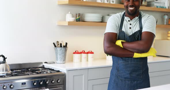 Smiling man standing with arms crossed in kitchen alt