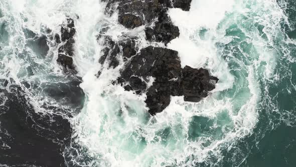 Aerial top view of rocks in the sea - Aerial video of majestic waves splashin