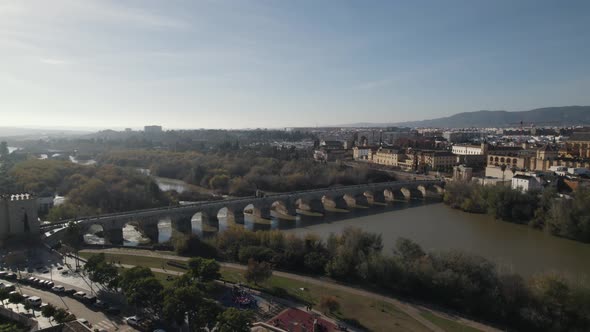 Slow aerial pan of Roman bridge and Mosque-Cathedral of Cordoba across river