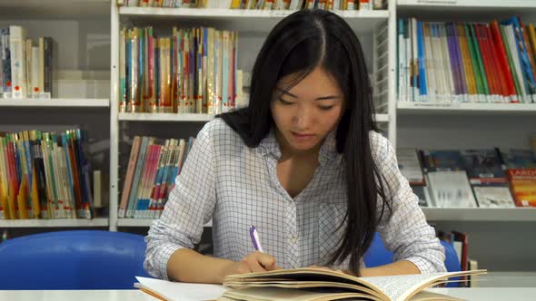 Female Student Studies at the Library alt