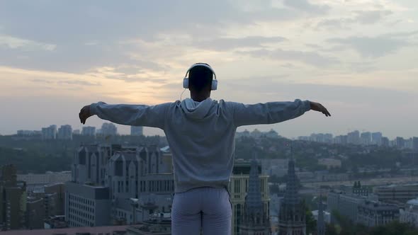 Athlete Doing Yoga at Edge of Roof, Receiving Charge of Vivacity and Relaxation alt