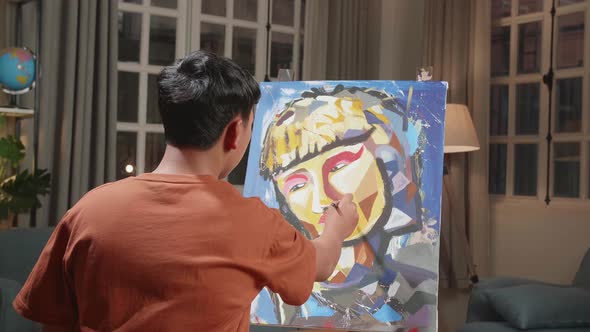 Asian Artist Boy Holding Paintbrush Mixed Colour And Painting A Girl's Hair On The Canvas alt