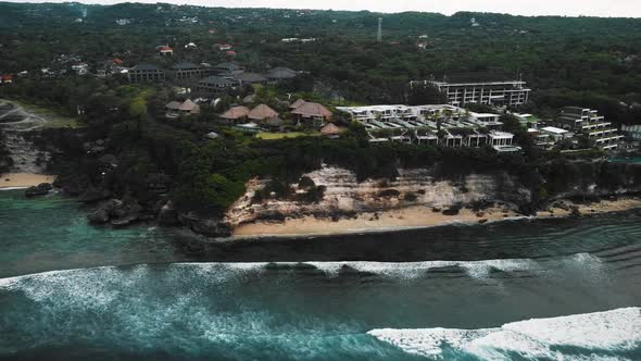 Beautiful Bingin beach with exotic cliffs houses and hotel located in Bali, Indonesia. This drone fo alt