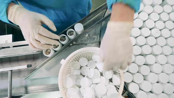 Tubs with Pills are Getting Closed on the Conveyor in a Top View alt