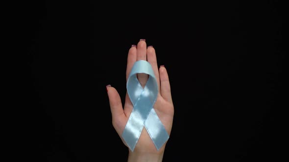 World Diabetes Day. Blue Ribbon Symbolic Isolated with Hand Support alt