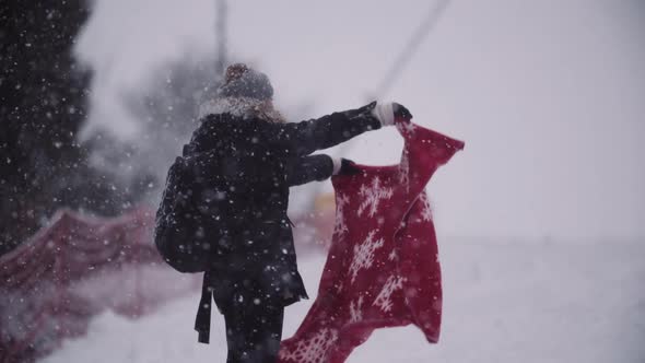 Close Up of Frozen Woman Wrapped in a Blanket at Snowstorm alt
