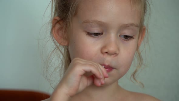 Close Up of Little Girl Sucks Sweet Fruit Lollipop alt