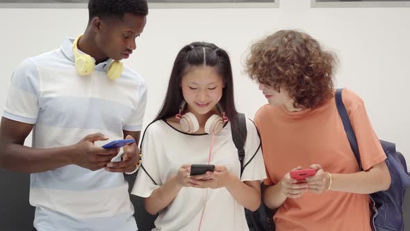 Young Teenage Friends Using Cell Phones in High School alt