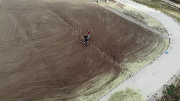Aerial shot of workers assembling irrigation system on school football stadium. alt