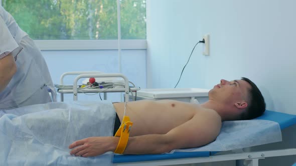Nurse Performing Electrocardiography on a Male Patient alt