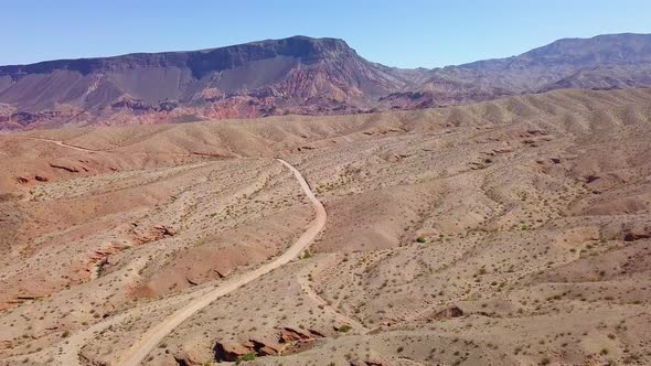 Aerial drone view overlooking sand road in Kingman wash, sunny day in Arizona, USA alt