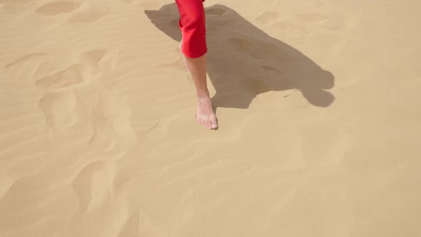 Sexy Brunette Woman in a Red Satin Long Dress Walks on Sand Dunes in the Desert alt