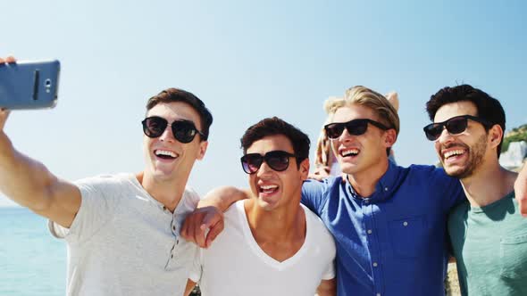 Friends taking selfie from mobile phone at beach alt