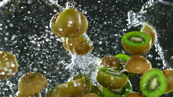 Super Slow Motion Shot of Flying Fresh Kiwi Slices and Water Splash ...