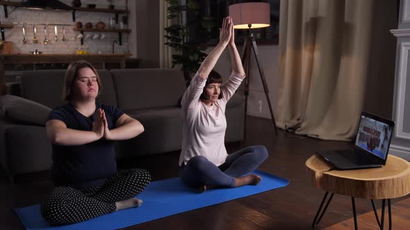 Handicapped Girl with Mom Meditating in Lotus Pose alt