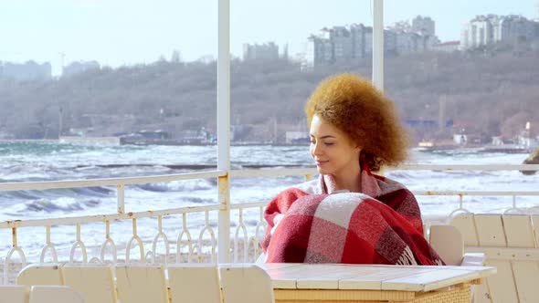 Beautiful Pensive Redhead Woman Sitting at the Beach Watching the Sea