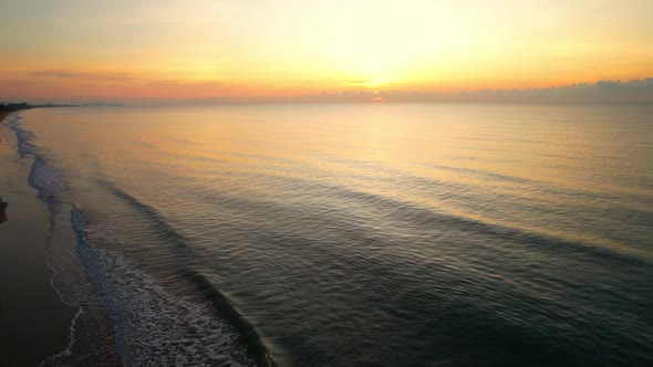 An aerial view of a drone flying over a sandy beach alt