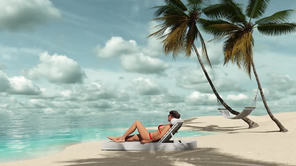Girl resting on a sun lounger near the sea on the beach among palm trees.