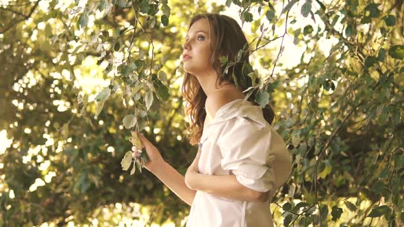 Beautiful Young Sexy Girl In A White Shirt Walks Along River Bank Among Trees alt