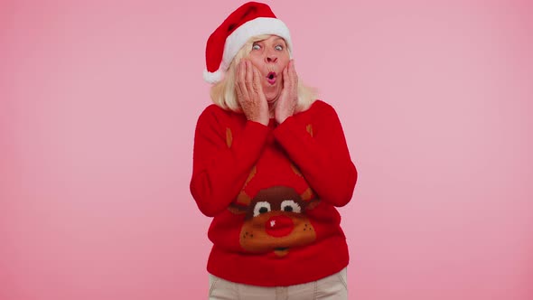 Grandmother in New Year Deer Sweater Raising Hands in Surprise Shocked By Sudden Victory Wow Emotion alt