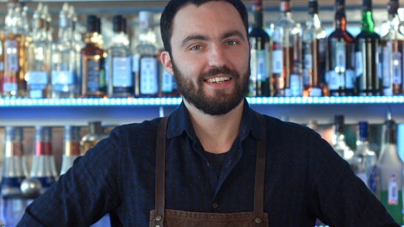 A barman at work smiling and looking at camera